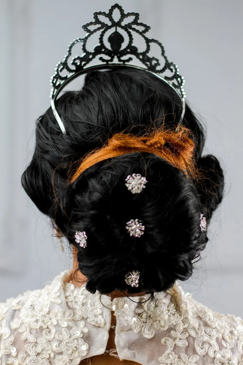 Bridal hairstyle featuring a tiara and decorative hair ornaments for a luxurious look.