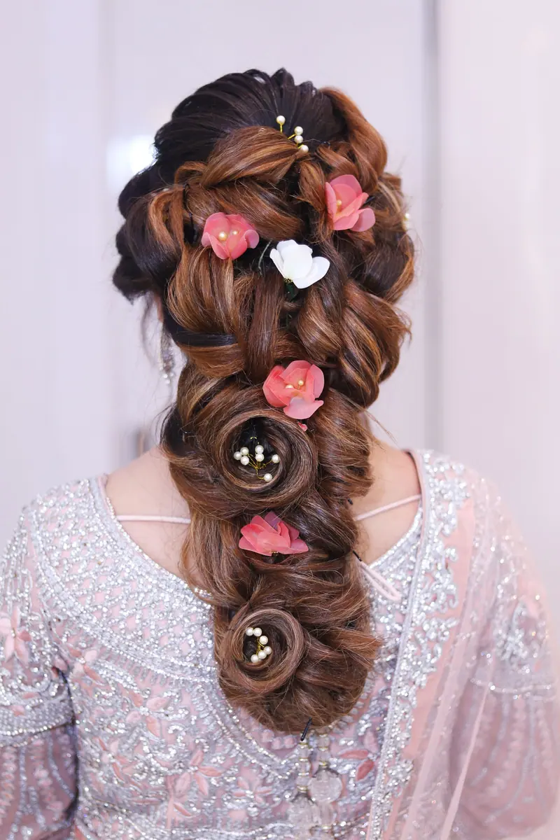 Stunning elegant braid adorned with pink and white flowers, perfect for bridal looks.
