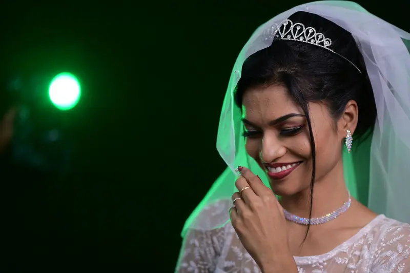A smiling bride with a tiara and veil, highlighting her joyful and elegant charm.