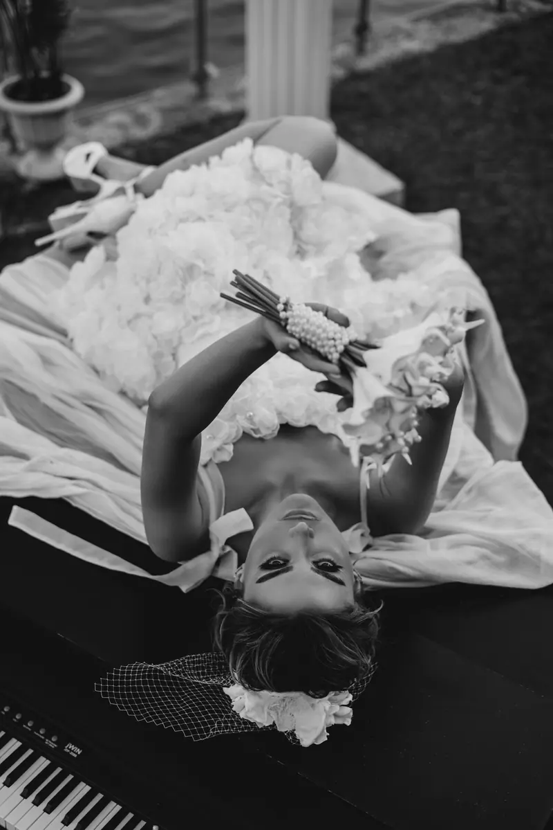 Black and white photo of a bride in a wedding dress posing with a bouquet outdoors in İstanbul.