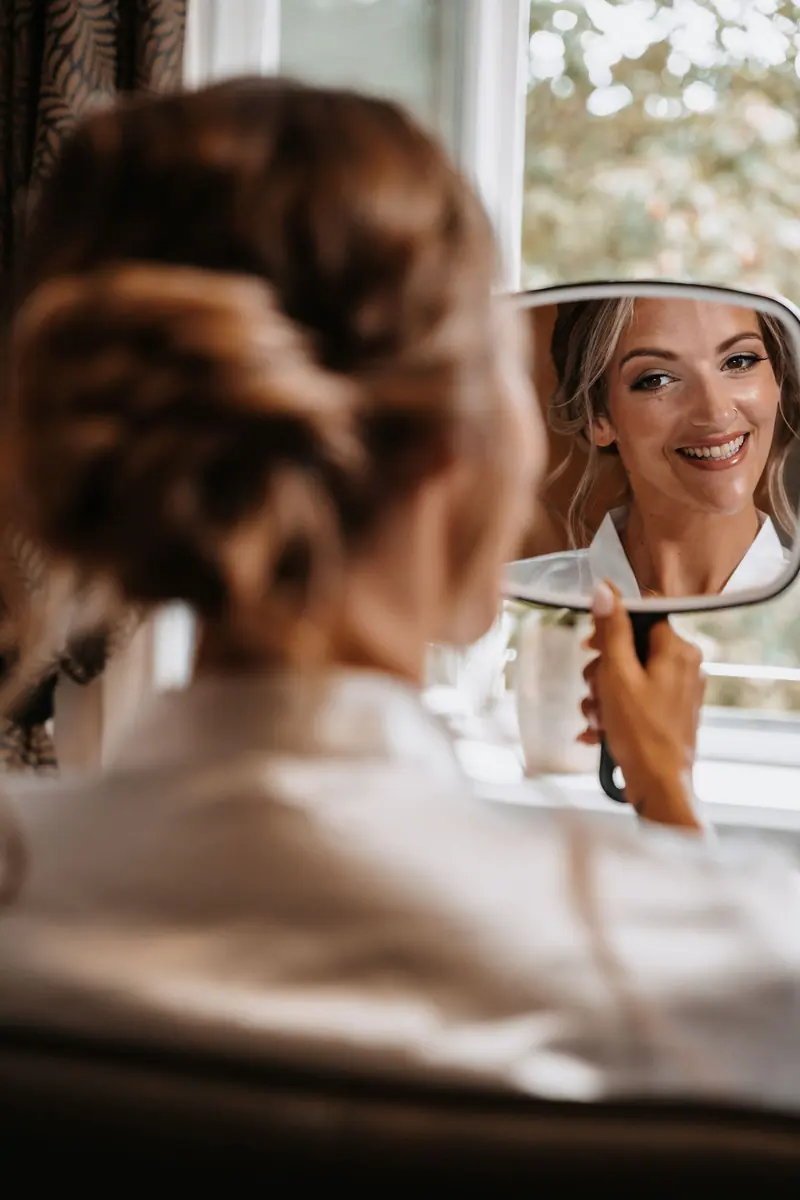A beautiful bride admiring herself in the mirror, preparing for her wedding day.