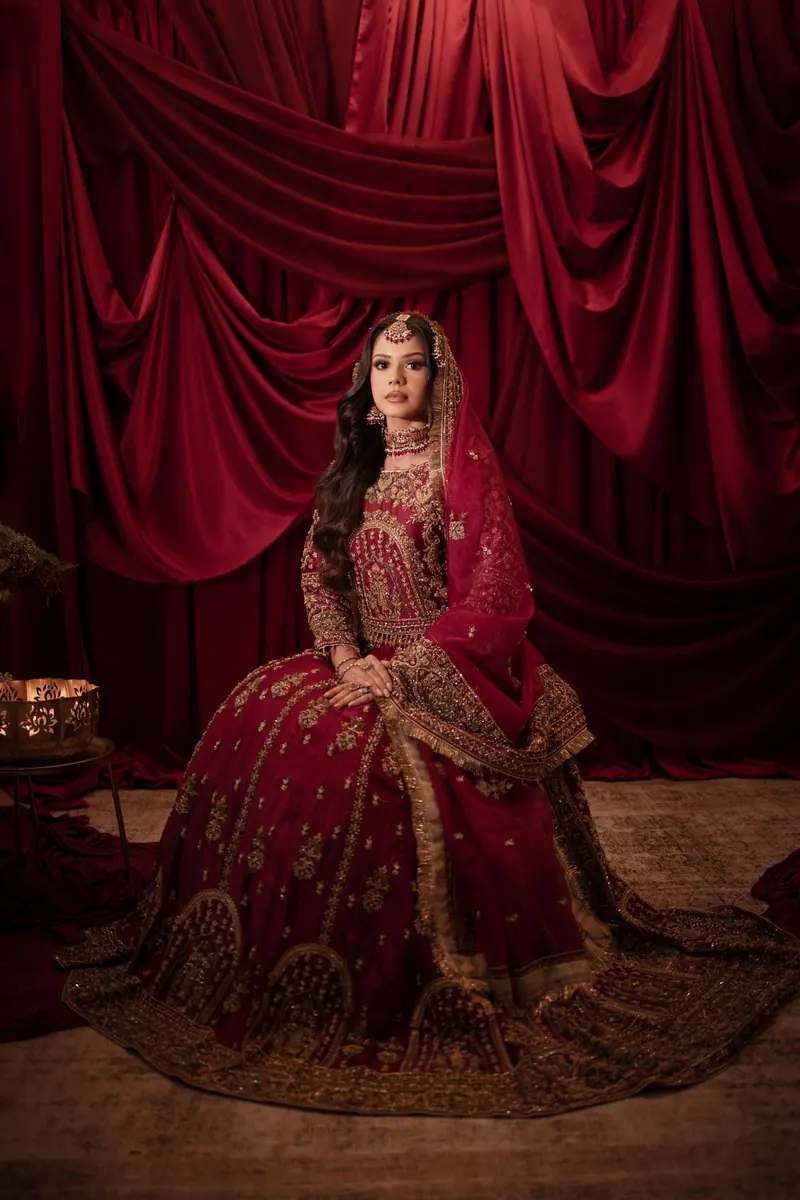 Stunning portrait of a bride in ornate red attire against a luxurious backdrop.