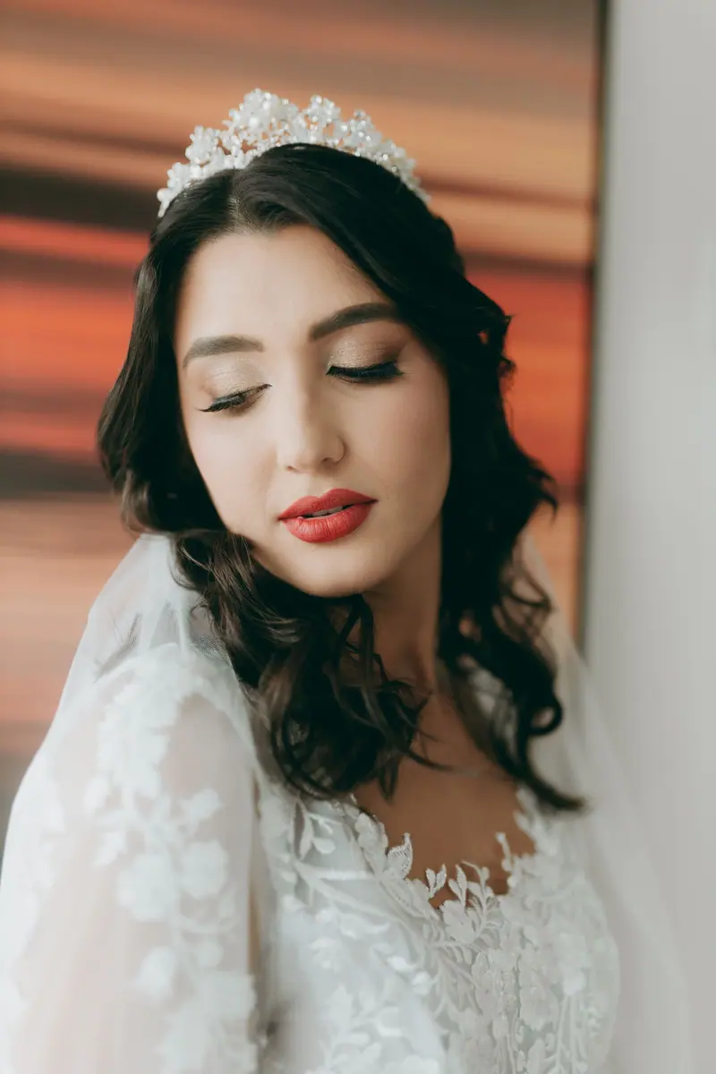 Stunning bridal portrait featuring a woman with tiara and lace gown, captured with soft lighting.