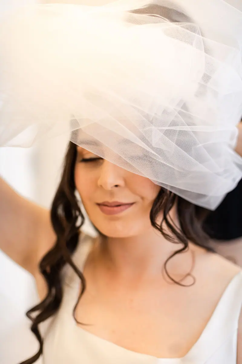 Captivating portrait of a bride adjusting her veil during a serene moment in São Paulo.