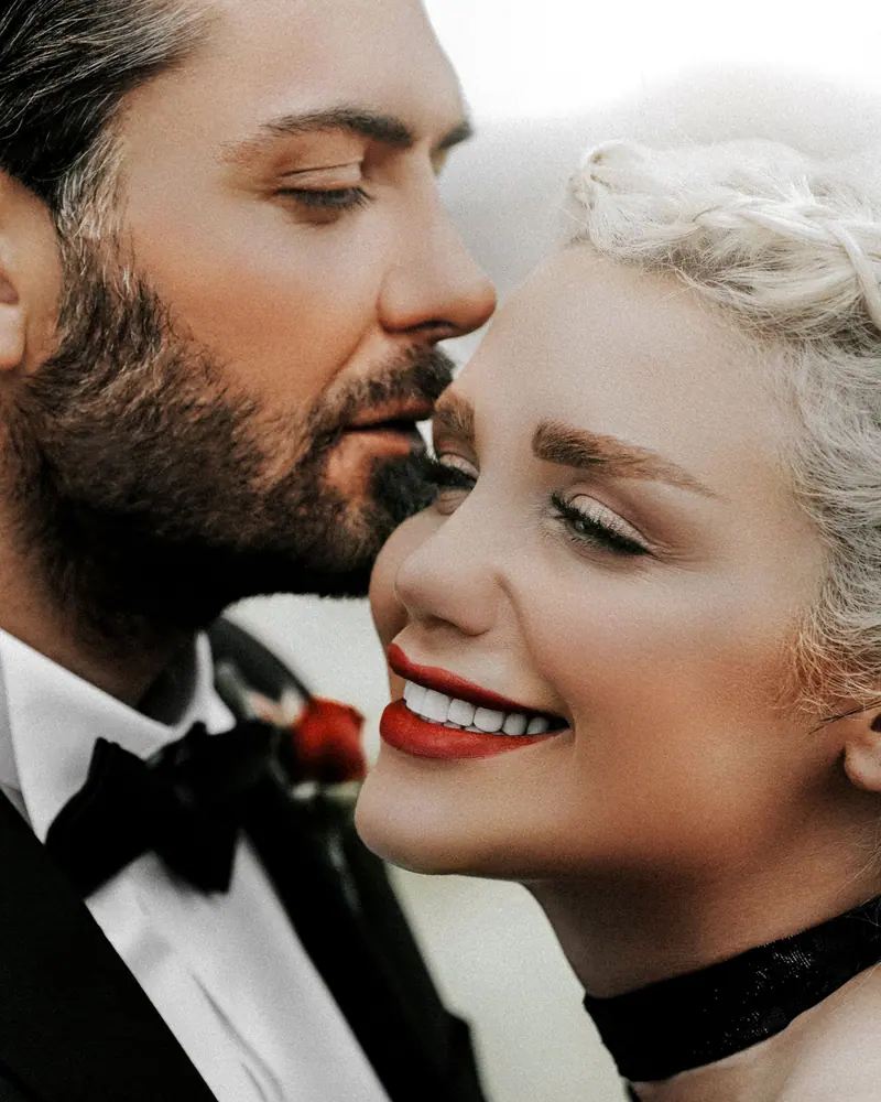 A joyful bride and groom embrace in a loving moment, showcasing happiness and romance in a wedding setting.