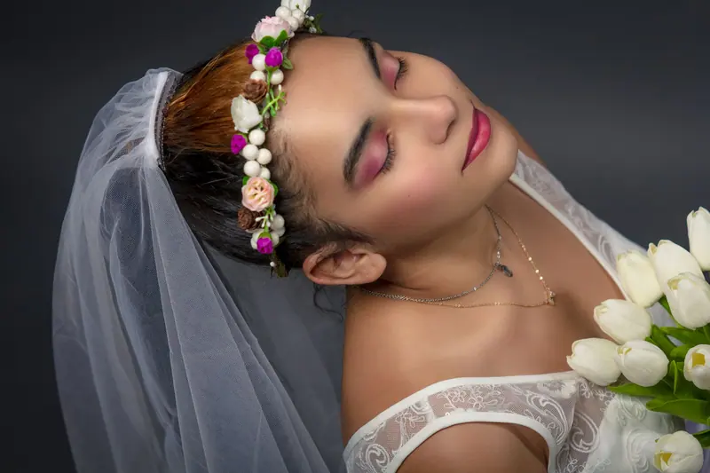 A serene bridal portrait featuring a flower crown and elegant veil, highlighting wedding beauty.