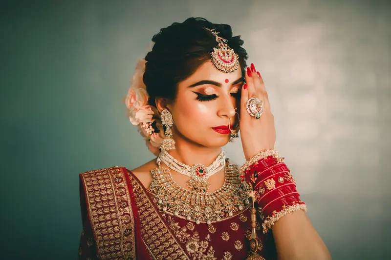 A beautiful Indian bride in traditional attire with exquisite jewelry and makeup.