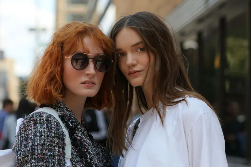 Stylish women posing outdoors in New York City, showcasing urban fashion trends.