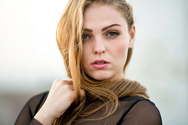 Close-up portrait of a beautiful young woman with blonde hair and striking eyes.
