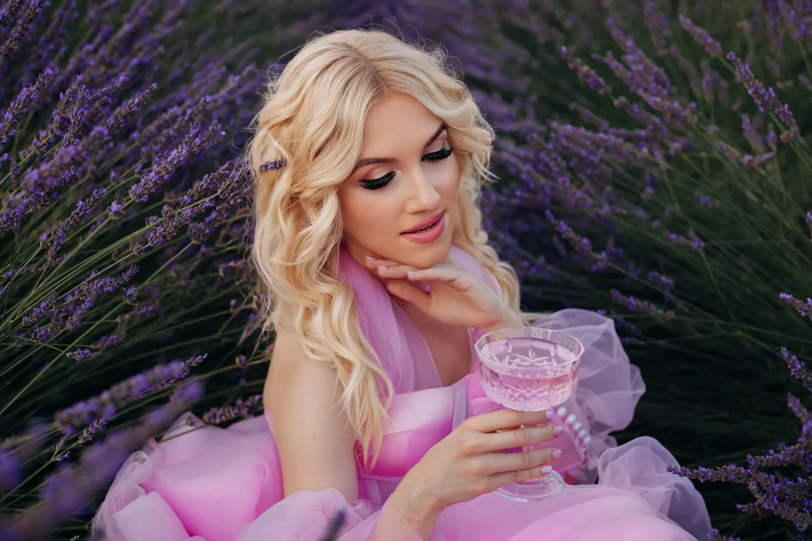 Platinum blonde in a pink tulle gown sitting in a lavender field at golden hour