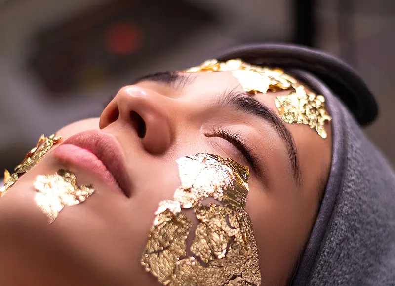 Close-up of a face adorned with gold leaf