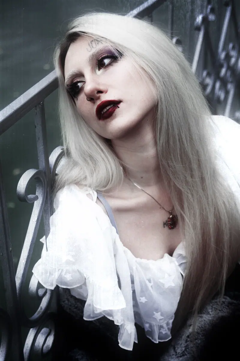 Gothic style portrait of a woman with platinum blonde hair and dark makeup.