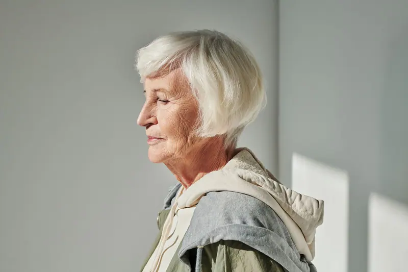 Portrait of a stylish senior woman with white hair in a relaxed pose.
