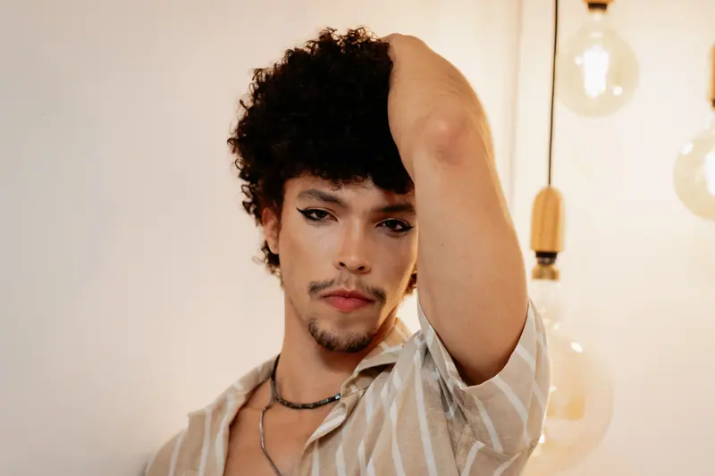 Captivating portrait of a young man with curly hair in a stylish pose in São Paulo.