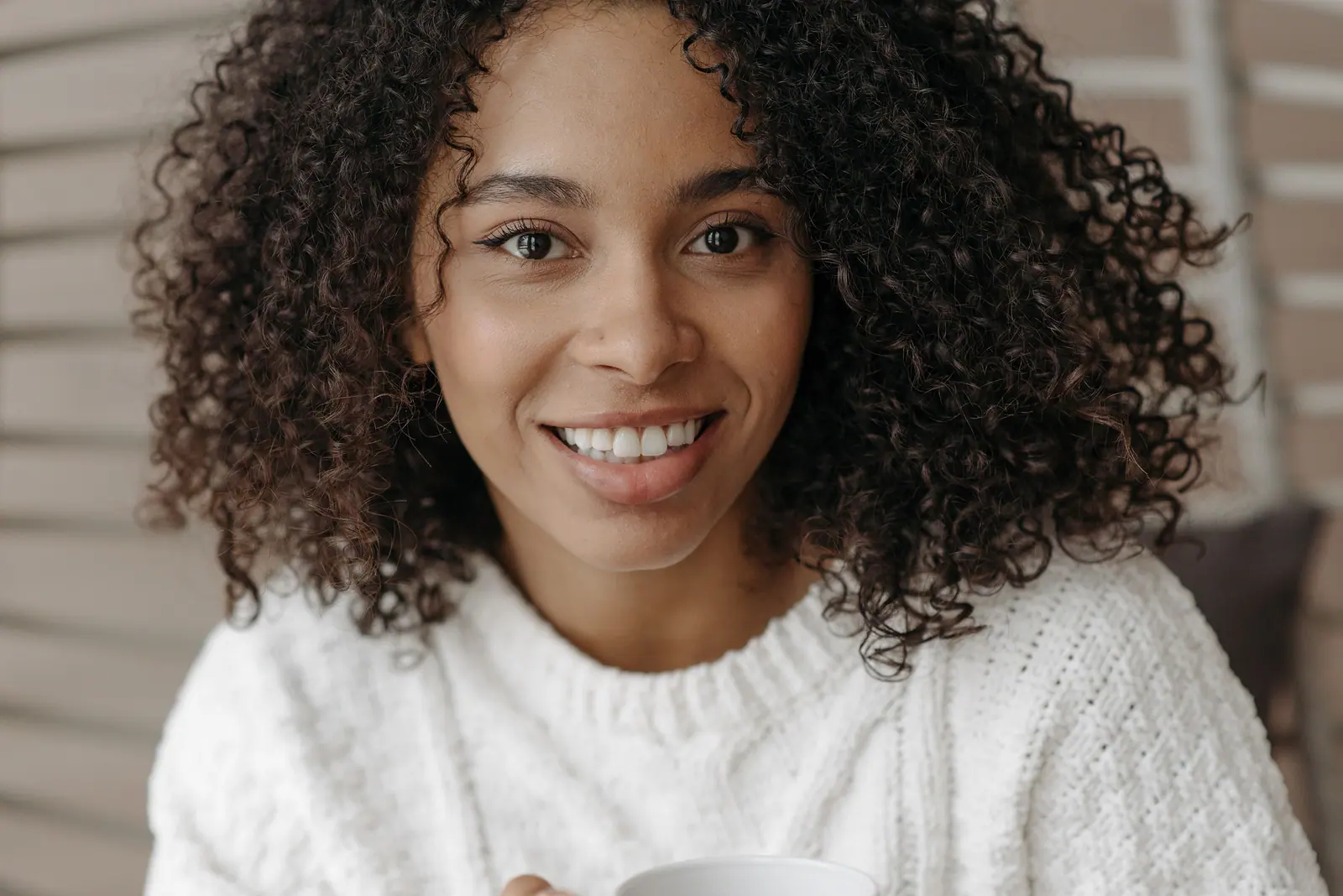 Smiling woman with defined curls in soft daylight