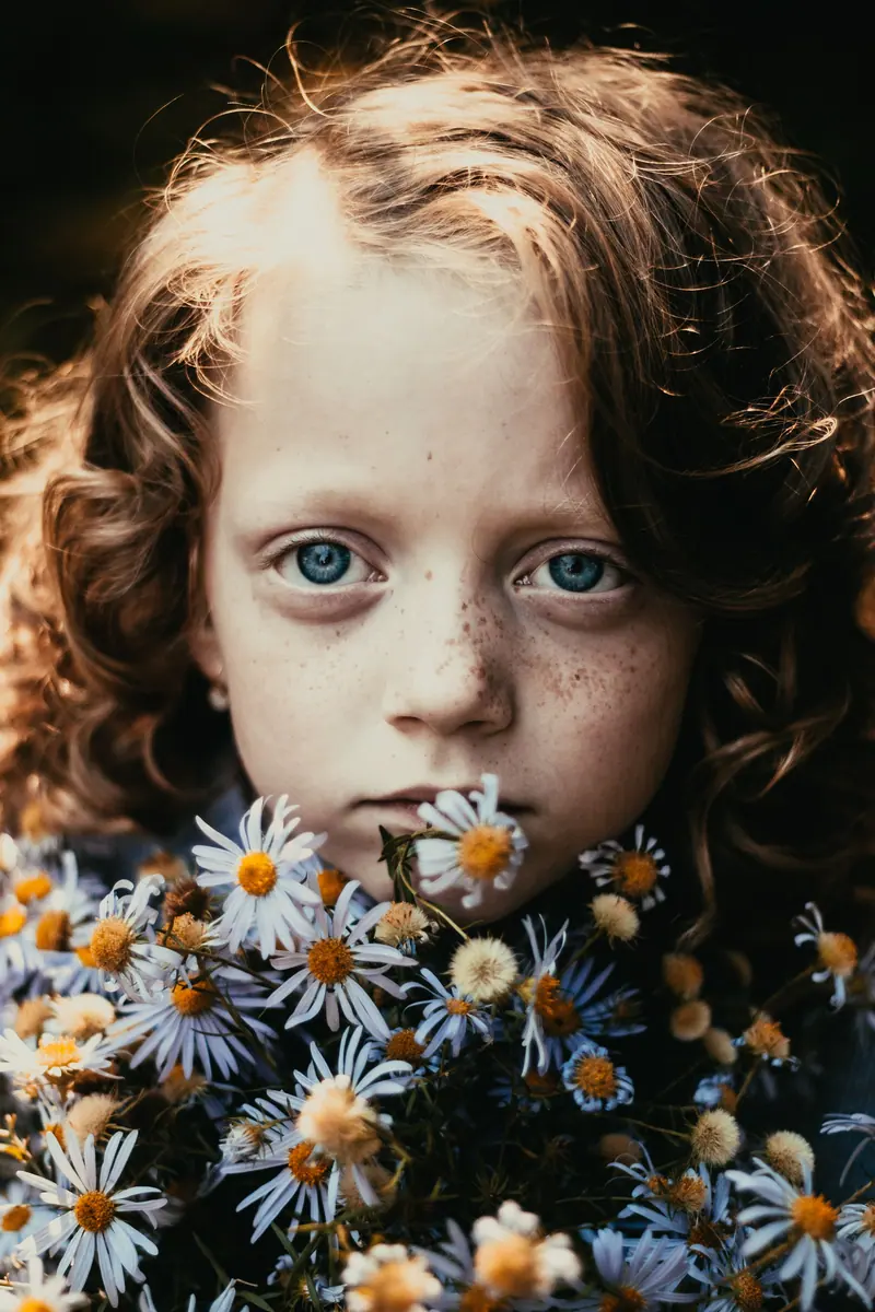 Enchanting portrait of a redhead girl surrounded by delicate white flowers.