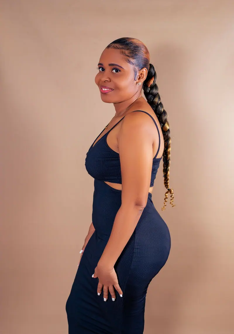 Elegant portrait of a woman in a blue dress showcasing braided hair in a studio setting.