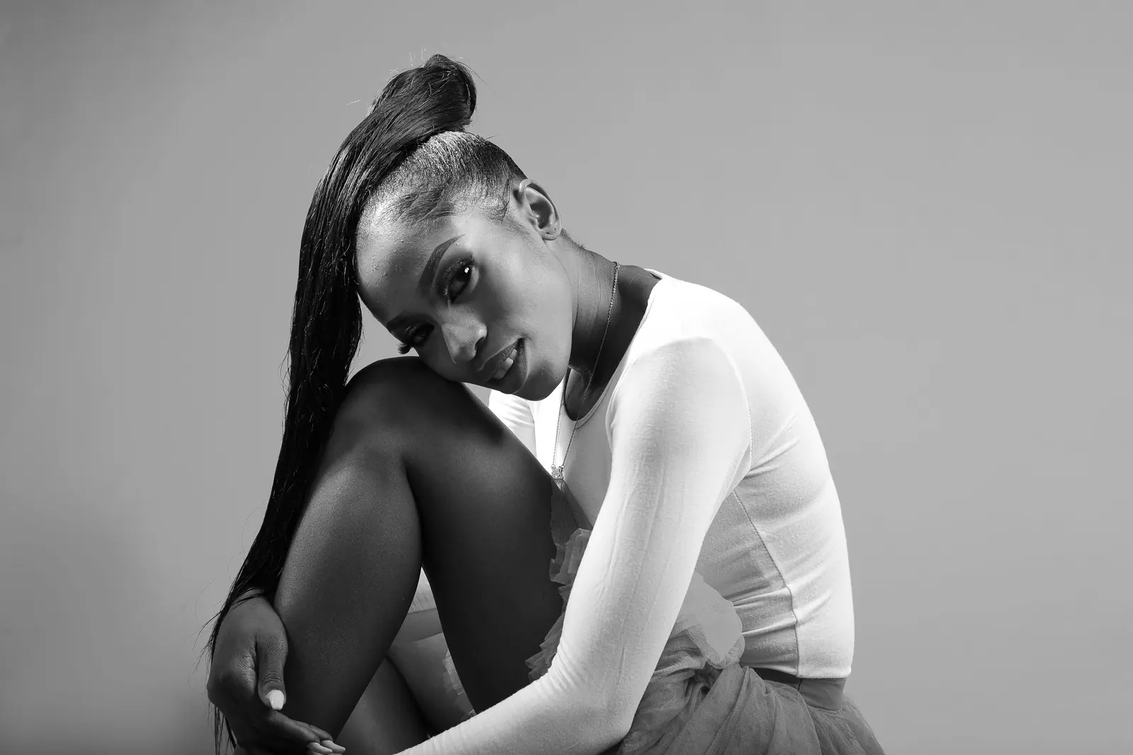 Black-and-white portrait of a woman with a long, sleek extended ponytail