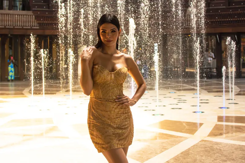 Long brunette waves among golden fountain light