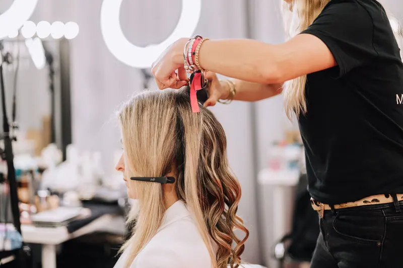 Artist styling long hair at the station