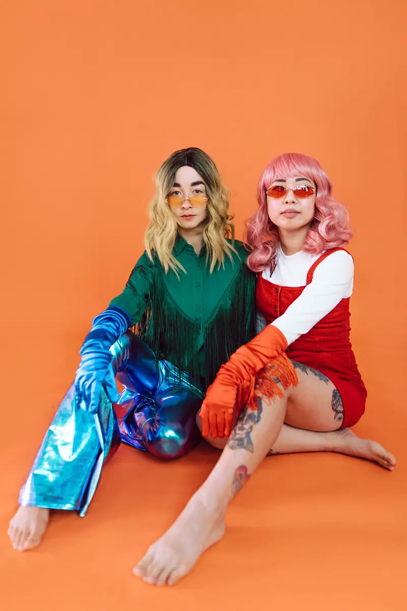 Friends in colorful wigs on orange