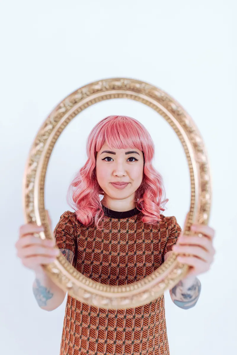 Pink wig framed in a gold mirror
