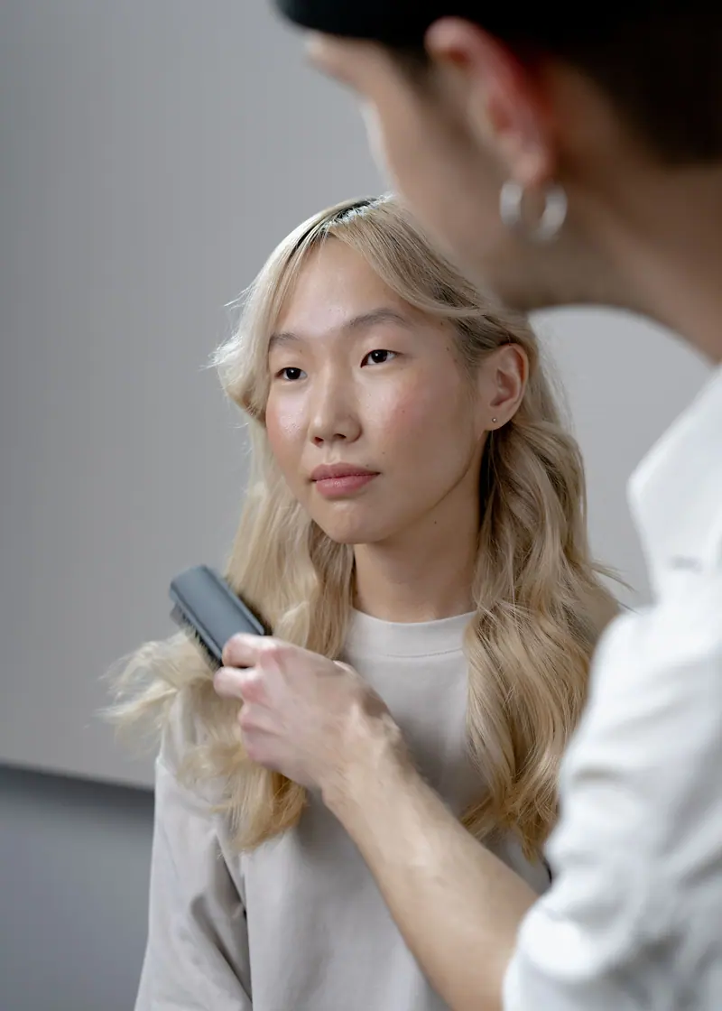 Stylist blending a client's blonde lengths
