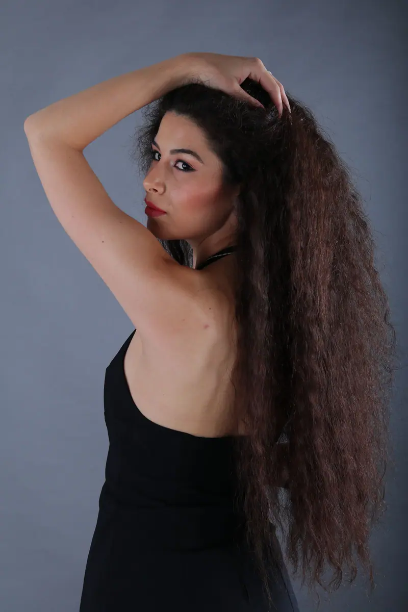 Very long curly lengths against blue-grey