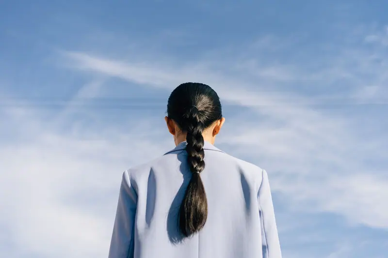 Long braided ponytail against a blue sky