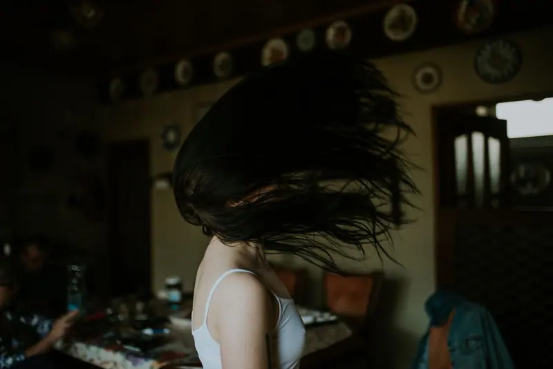Captivating indoor shot of a woman flipping her hair, creating motion and energy.