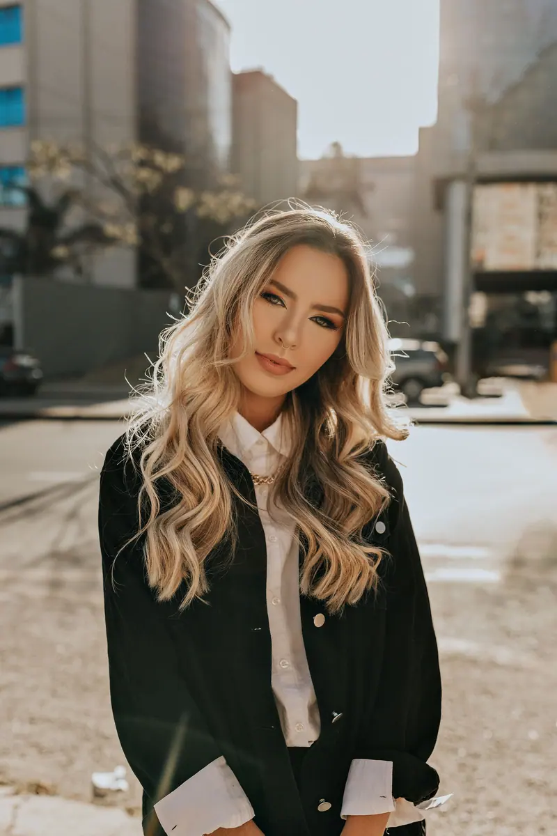Long blonde waves styled with a jacket