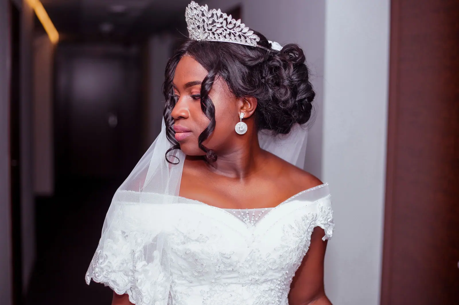 Bride with a sculpted curled updo, crystal tiara and veil