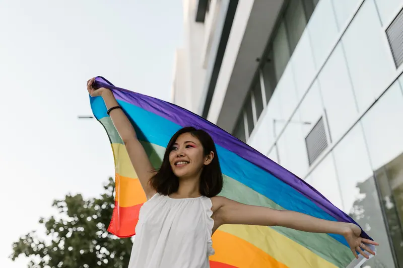 Woman holding a rainbow flag above her head