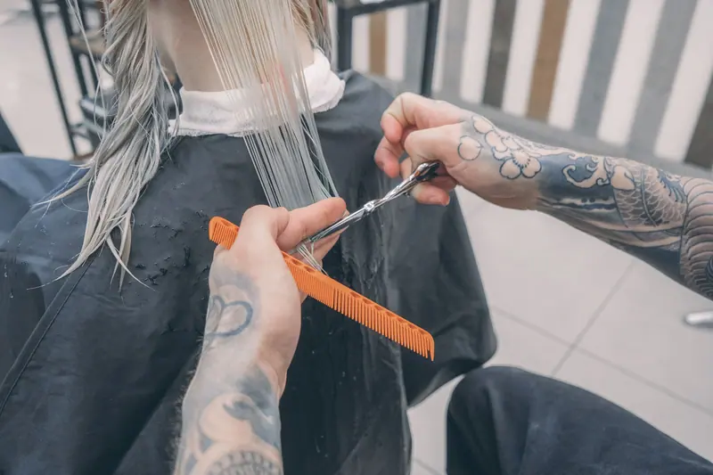 Tattooed hands cutting long platinum hair