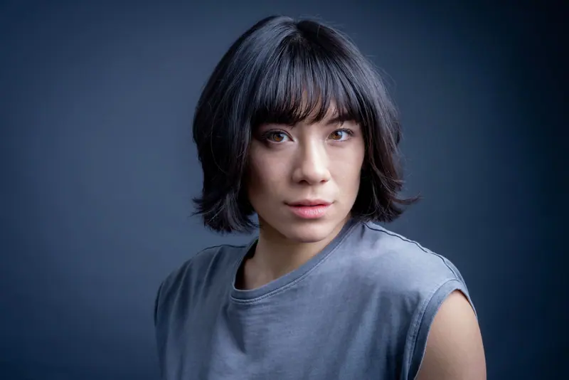 Glossy bob in a grey tee on navy