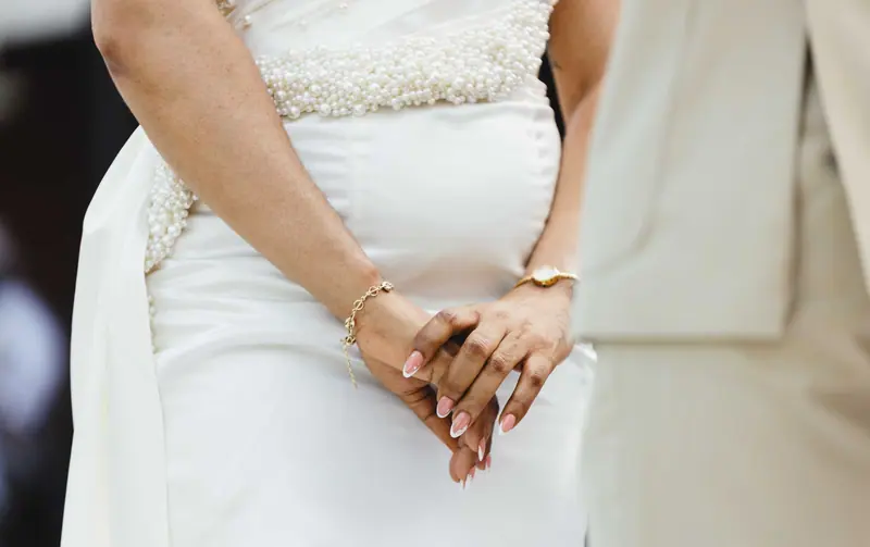 Hands clasped over a beaded gown