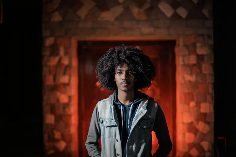 Big curls in a red-lit doorway