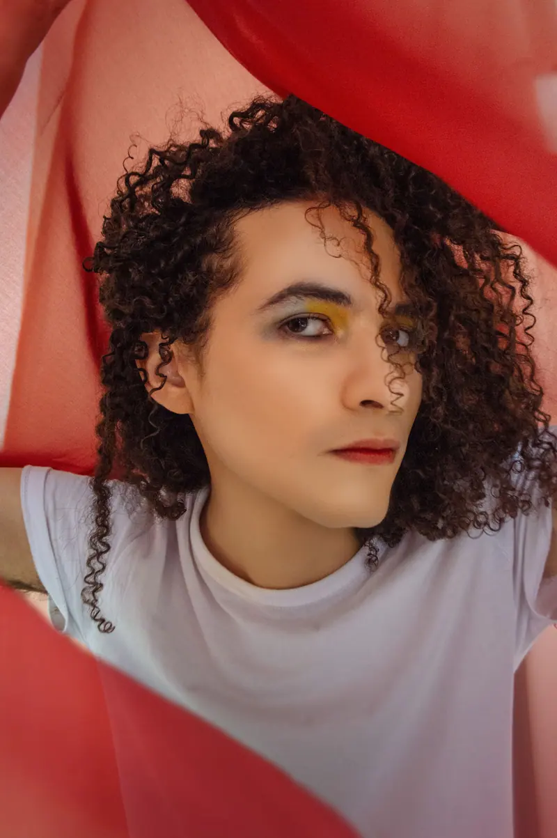 Dark curls framed by red fabric