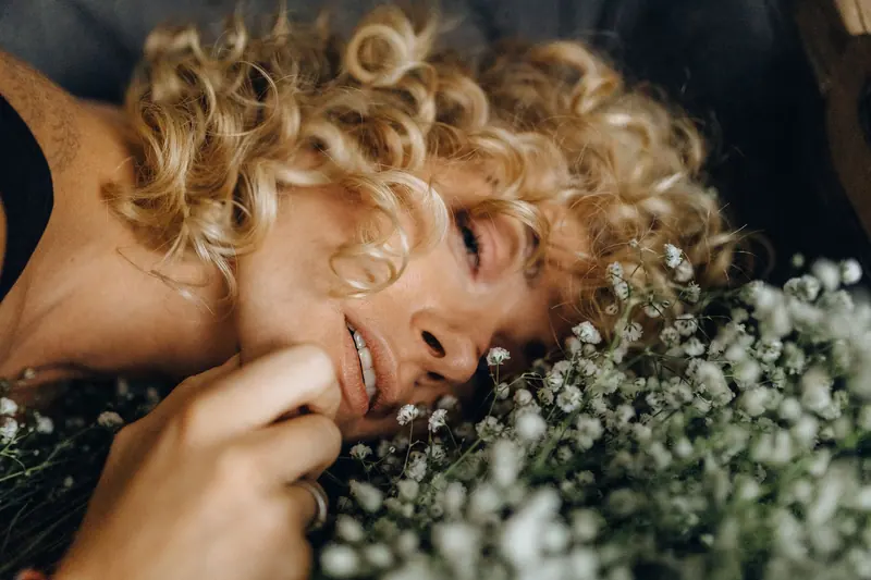 Laughing blonde curls resting in baby's breath