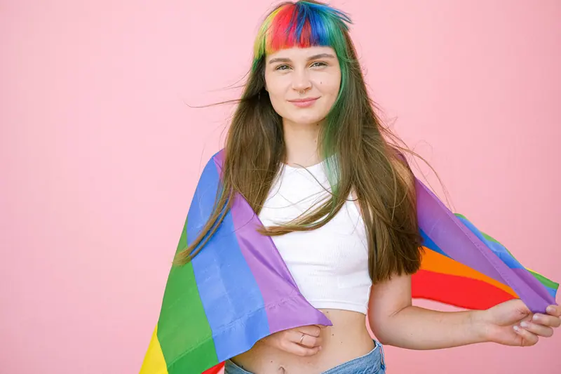 Rainbow fringe and a pride flag worn as a cape