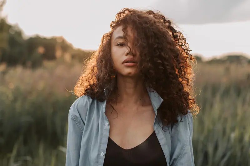 Curls and a denim shirt by the reeds
