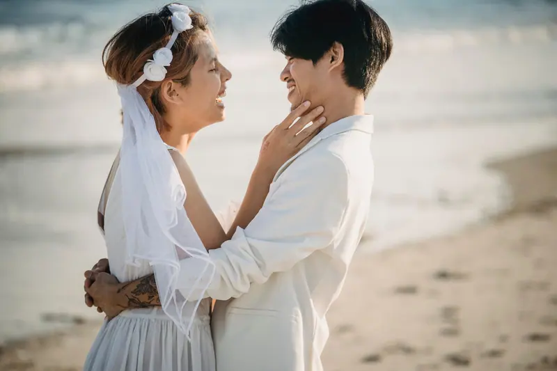 Couple embracing on the beach in wedding white
