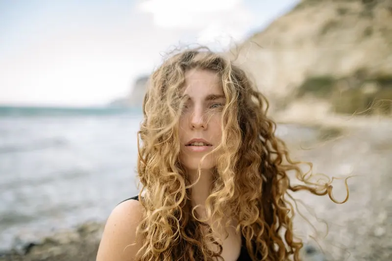 Windblown honey curls by the sea