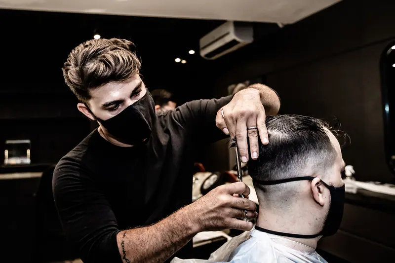 Barber cutting in a dark studio