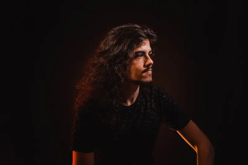 Long curls in amber rim light