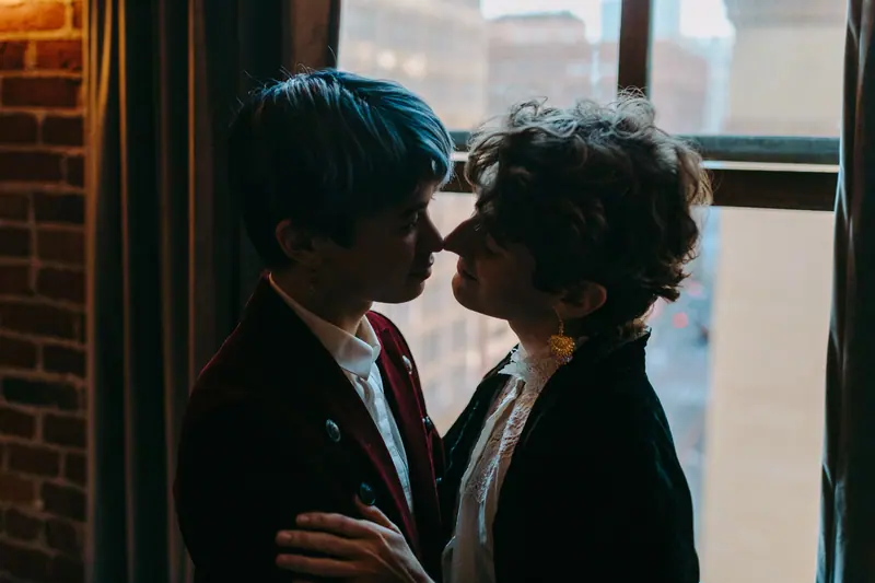 Couple in suits by a city window
