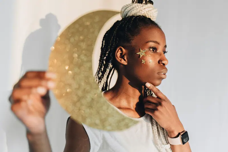 Braids and a gold moon in profile