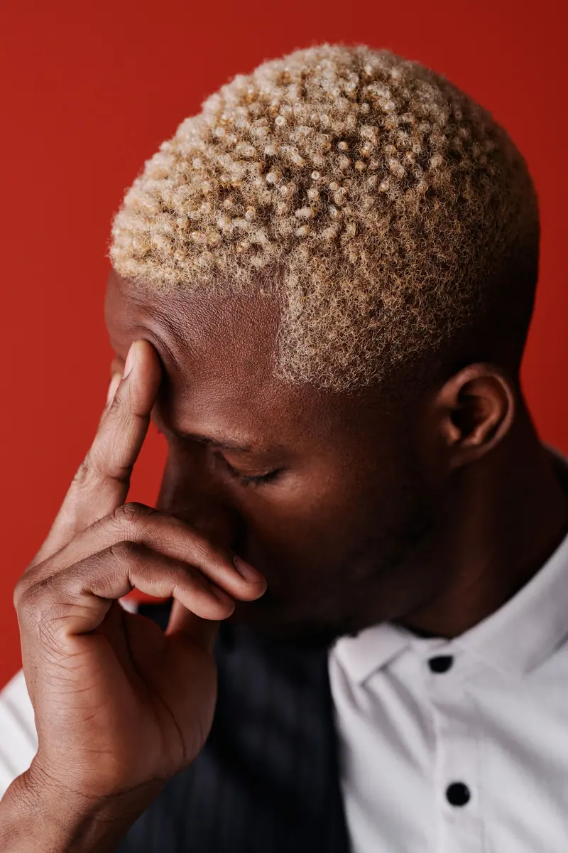 Bleached blonde coils against a red background