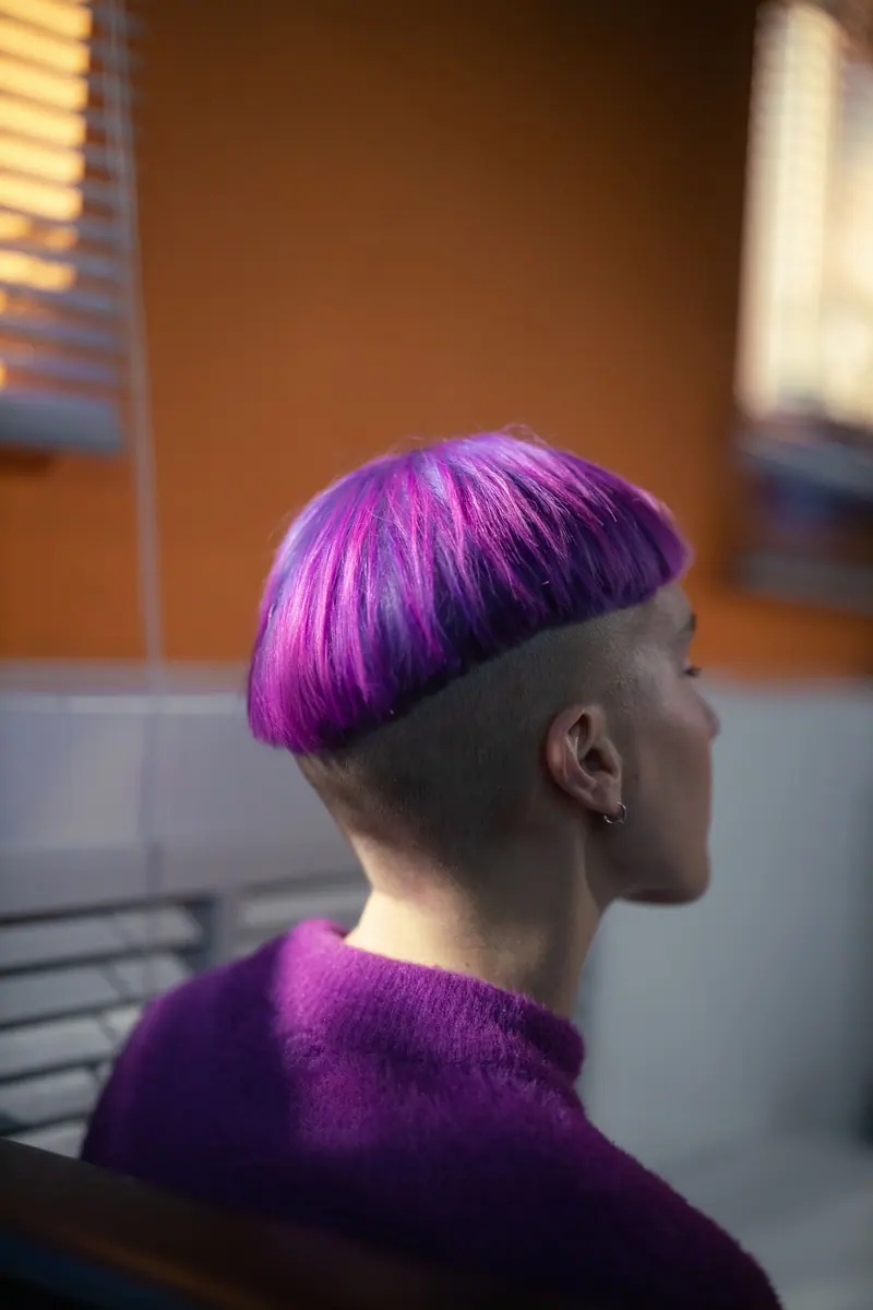 Violet bowl cut over a shaved undercut, seen from behind