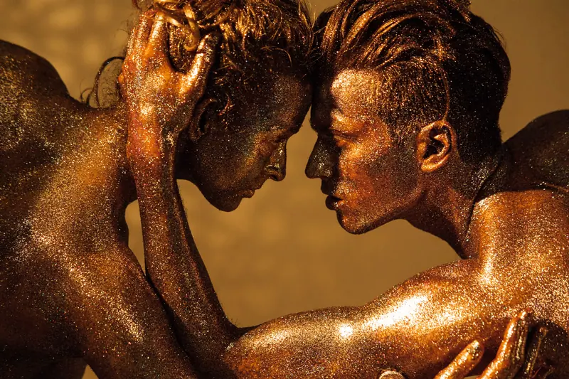 Two dancers in gold body shimmer